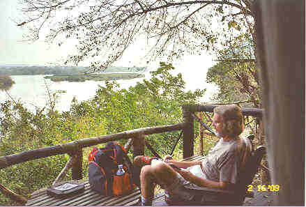 The 'Porch' in front of our tent offers a grand view across the Victoria Nile.  While we have a moment, I make entries in my journal.  Photo by Jungle Jim.