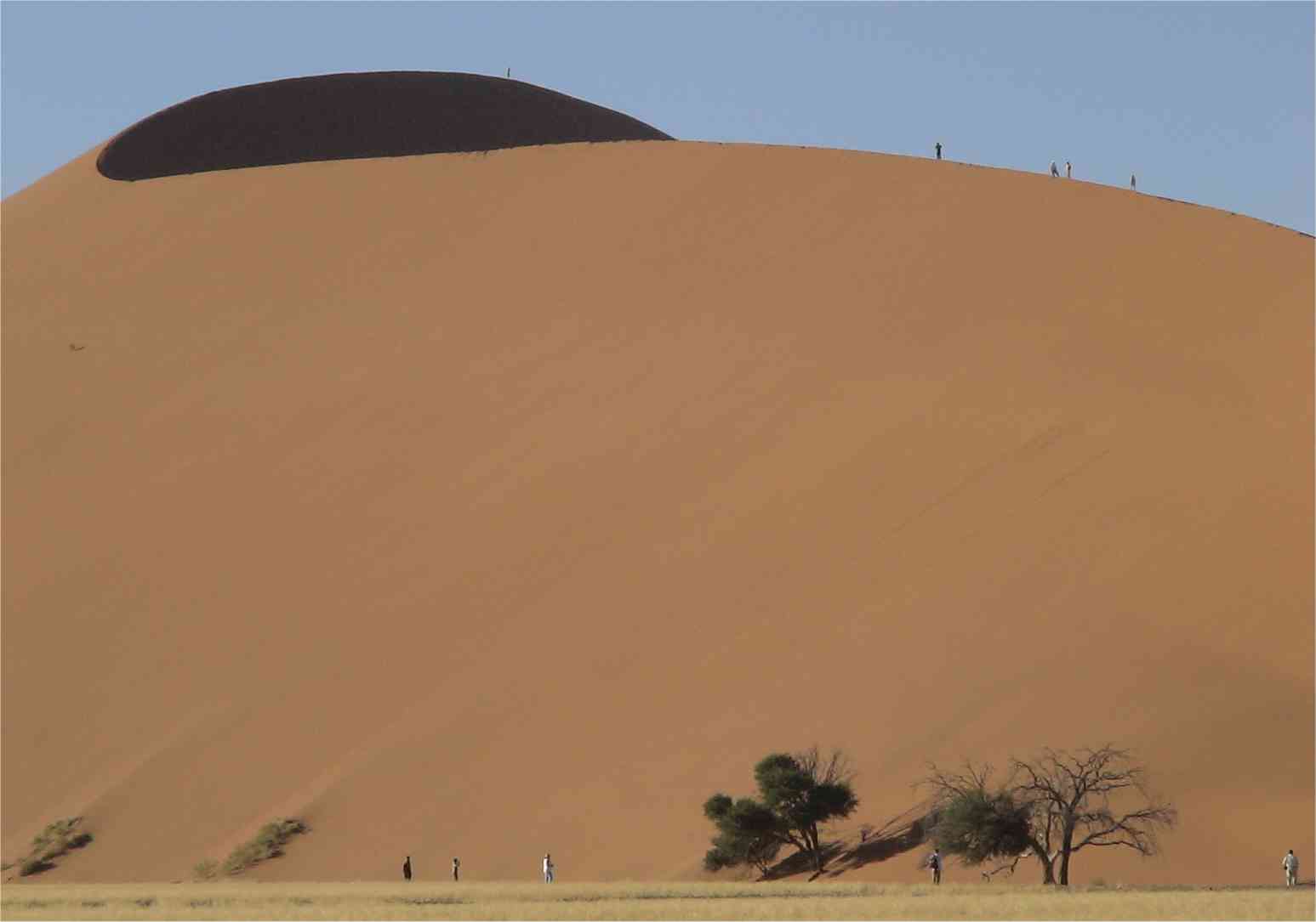People look like ants on the edge of the dunes. Photo by FG.
