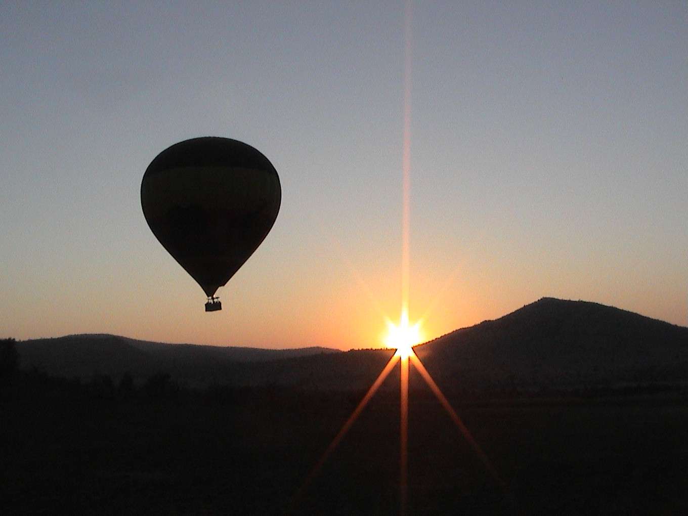 The early-morning sun peaks out from behind a mountain.  Photo by FG.