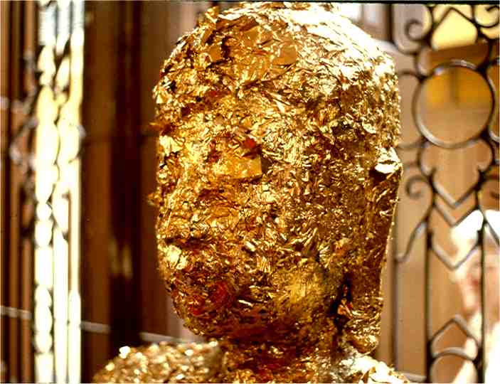 It's customary to buy tiny sheets of gold leaf and attach it to statues. This statue is covered with the stuff. Photo by FG.